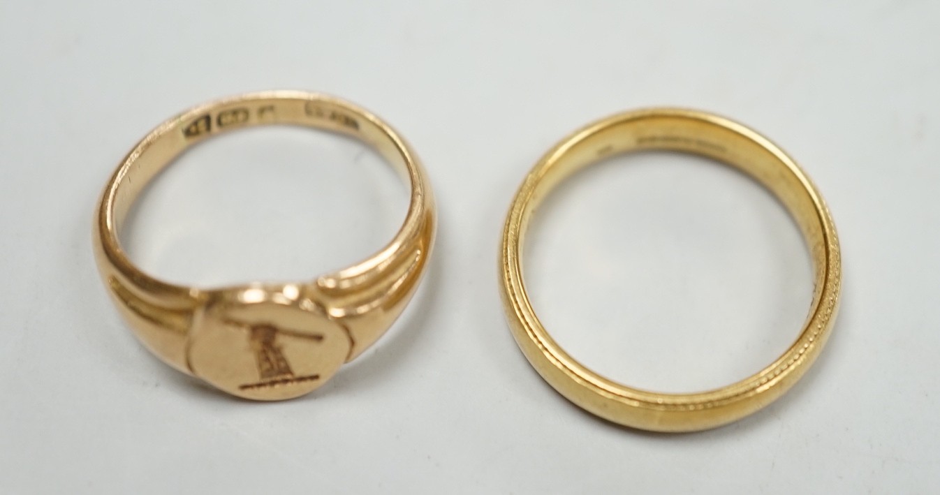 An early 20th century small 18ct gold signet ring, engraved with armorial, size G/H and a modern 18ct gold band, size I, with engraved inscription, 7.6 grams.